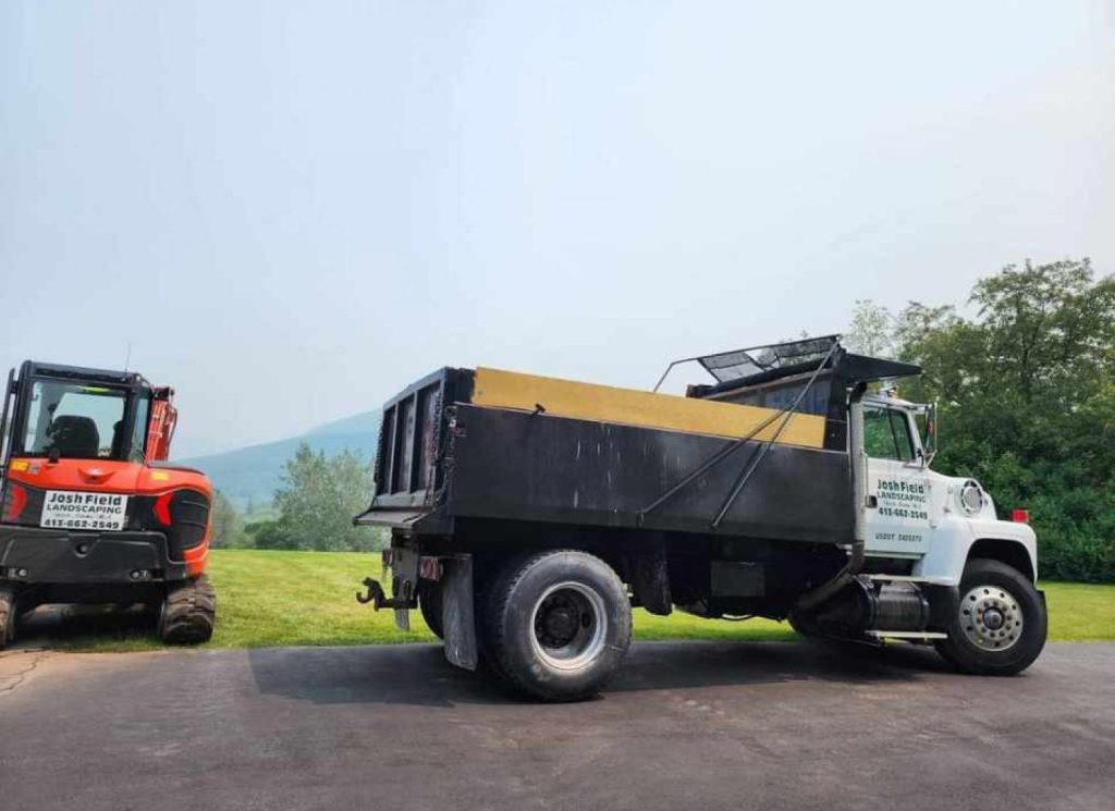 Dump truck and Kubota machine on a job site by Josh Field Landscaping