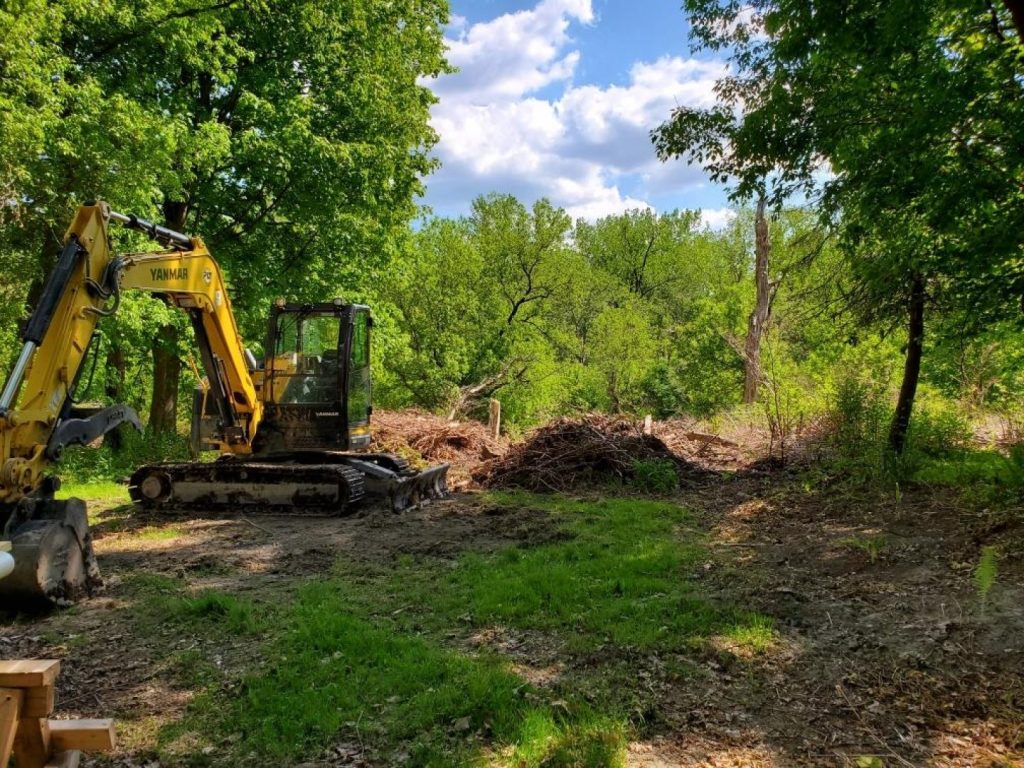 Mini excavator clearing a lot by Josh Field Landscaping