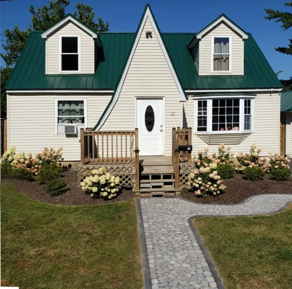Cottage with stone walk and hydrangeas by Josh Field Landscaping