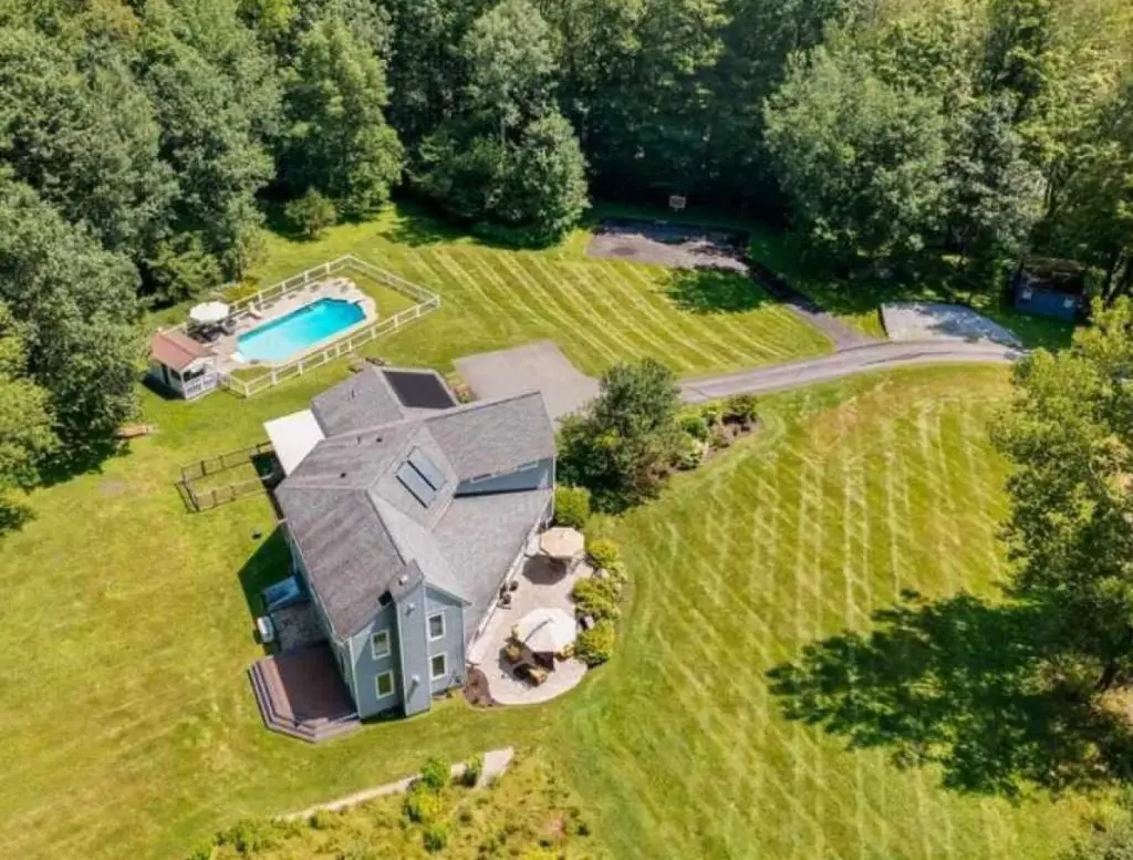 Aerial view of a striped estate lawn with pool by Josh Field Landscaping