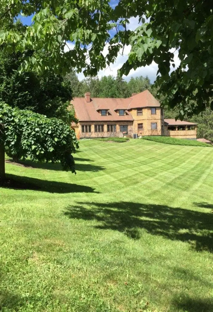 Striped lawn with a house in the distance by Josh Field Landscaping