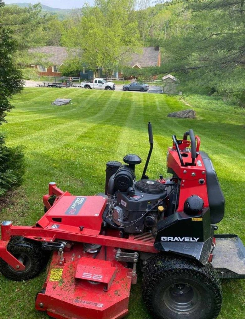 Commercial zero-turn mower on a striped lawn by Josh Field Landscaping