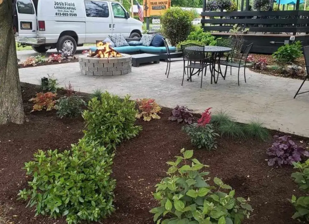Concrete patio with fire pit and new plantings by Josh Field Landscaping