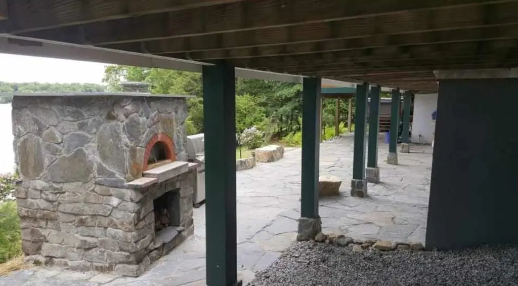 Stone pizza oven under a covered patio by Josh Field Landscaping